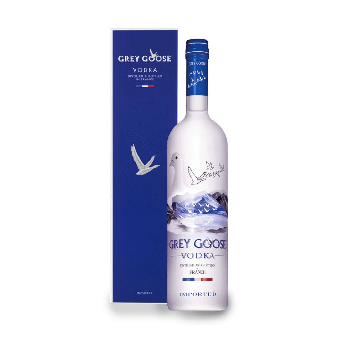 A bottle of Grey Goose Vodka with a blue label, alongside its blue packaging box. The bottle has a white cap and the label indicates that it is a 1L bottle.